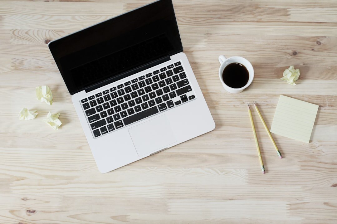 Modern minimalist desk with laptop, notebook and coffee cup